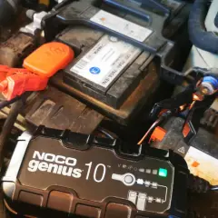 Ładowarka NOCO Genius 10 podłączona do akumulatora samochodowego. Tak, można ładować akumulator podłączony do samochodu.