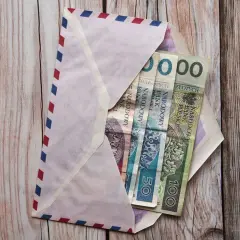 Koperta z pieniędzmi na komunię. Chrzestny zastanawia się, ile dać na komunię chrzestny.