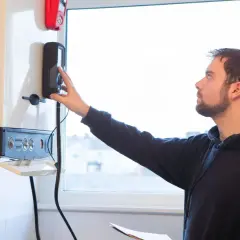 Un technicien ajuste la commande d'une chaudière à condensation.