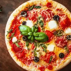 Leckere Pizza mit Salami, Mozzarella und Oliven auf einem Holzbrett. Ein schneller Pizzateig ohne Hefe macht sie im Handumdrehen fertig.
