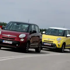 Dwa samochody Fiat 500L, jeden czerwony, drugi żółty, jadą po zakręcie drogi.