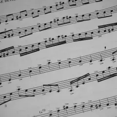 Fragment nut z oznaczeniem "Legato" i cyframi wskazującymi na artykulację. Widać nuty, kreski taktowe i znaki chromatyczne, sugerujące zakończenie utworu, czyli coda.