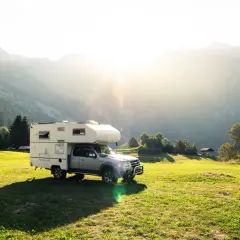 Camping-car dans un paysage montagneux ensoleillé, un endroit idéal pour le meilleur pays pour voyager en van.