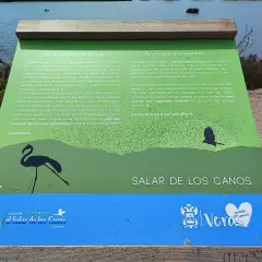 Un cartel informativo sobre el Salar de los Canos, un humedal costero y antiguo salinar, con siluetas de aves.