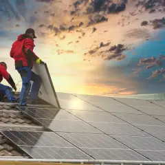 Instalatorzy montują panele fotowoltaiczne na dachu. Choć nie ma jeszcze podatku od fotowoltaiki, inwestycja w energię słoneczną to przyszłość.