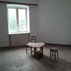 Puste mieszkania za odstępne w Łodzi. Stół, krzesło i stołek czekają na lokatorów.