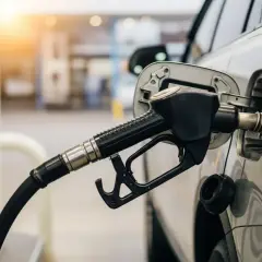 La manguera de una gasolinera surte el carburante de un coche.