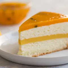 Pyszny tort mango z warstwami musu i galaretki, ozdobiony owocami. Idealny deser dla miłośników tropikalnych smaków.