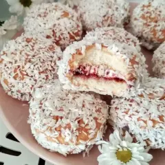 Pyszne ciastka biszkoptowe z nadzieniem owocowym i wiórkami kokosowymi, wyglądają jak małe śnieżne kuleczki.