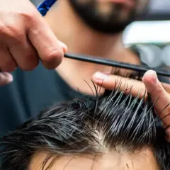 Strzyżenie męskie klasyczne maszynką krok po kroku. Fryzjer precyzyjnie modeluje włosy klienta grzebieniem i nożyczkami.