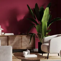 Elegancki salon z dominującym kolorem burgund. Jasne meble i drewniana komoda z rattanem tworzą przytulną atmosferę.