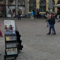 Zeugen Jehovas bieten einen kostenlosen Bibelkurs an. Menschen gehen vorbei, einige halten Broschüren in der Hand.