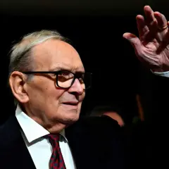 Ennio Morricone, kompositören bakom ikoniska filmer, vinkar med en ring på fingret.