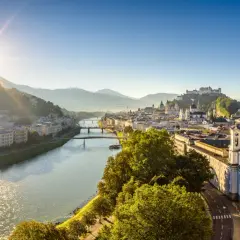 Sonnenaufgang über Salzburg. Die Salzach fließt durch die Stadt, im Hintergrund die Festung Hohensalzburg. Ein perfekter Morgen für smbs salzburg.