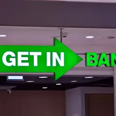 Zielona, podświetlana strzałka z napisem "GET IN" prowadzi do wejścia do banku.