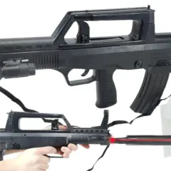 Dwa repliki karabinów ASG typu FAMAS z celowniczymi laserami i tarczami strzelniczymi.