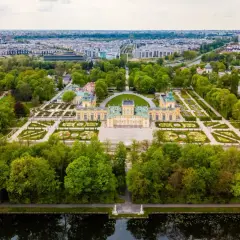 Pałac wilanowski i jego ogrody, symbol najbogatszej dzielnicy Warszawy, otoczone zielenią i rozległym miastem.