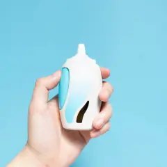 Dłoń trzyma biało-niebieski spray do nosa. To może być lek na alergię, np. momester.