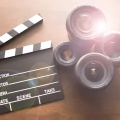 Klapka klaps i kilka obiektywów na drewnianym tle.