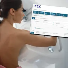 Kobieta przygotowuje się do mammografii. Na ekranie widoczny jest formularz wyszukiwania bezpłatnych badań po 50. roku życia.