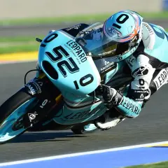 Danny Kent inclinado en su moto azul y negra, número 52, compitiendo en una carrera.