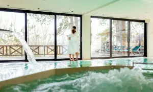 Pareja abrazada en un spa, disfrutando de la piscina y la vista. Así se hace en un spa: relajación y conexión.