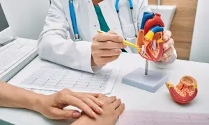 Lekarz omawia z pacjentem model serca i EKG, wyjaśniając szczegóły dotyczące świadczenia rehabilitacyjnego.