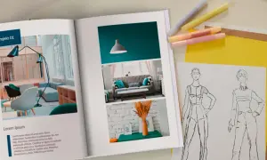 Otwarta księga prezentuje portfolio zawodowe z projektami wnętrz i szkicami mody.