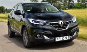 Czarny Renault Kadjar w ruchu. Kierowca w okularach przeciwsłonecznych. Wiele pozytywnych renault kadjar opinie potwierdza jego walory.