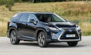 Mörkblå Lexus RX 450h körs på en väg, föraren ser ut att ha ett lexus rx 450h problem.