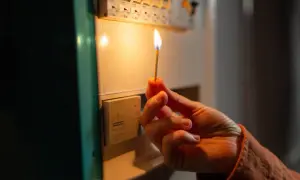 Mano con fiammifero acceso vicino al quadro elettrico, per capire cosa fare se salta la corrente.