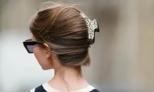 Elegancki french twist z ozdobną spinką, podkreślający szyję i okulary przeciwsłoneczne.