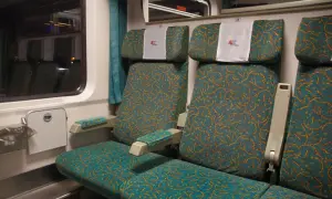 Wygodne siedzenia w wagonie bezprzedziałowym PKP Intercity. Wzór na tapicerce przypomina falujące linie.