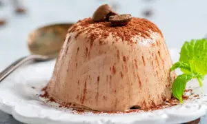 En krämig italiensk pannacotta, pudrad med kakao och toppad med kaffebönor. En frisk myntakvist ger en fin kontrast.