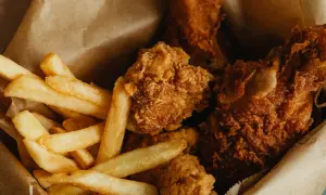 Krispiga chicken nuggets och gyllene pommes frites i en brun papperspåse. En klassisk kombination för en snabb och god måltid.