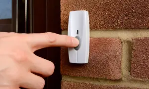 Main tenant appuie sur le bouton pour installer une sonnette sans fil.