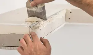 Nakładanie gładzi na narożniki aluminiowe, by je wzmocnić i wygładzić.