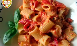Un piatto di pasta con peperoni rossi e basilico fresco. Un'esplosione di sapori mediterranei.