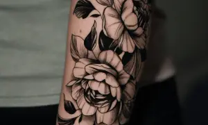 Un tatuaje de peonías en blanco y negro en un brazo. Una inspiración para saber como elegir un tatuaje que te represente.