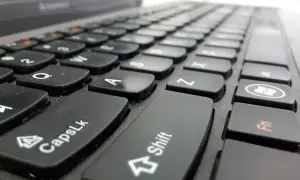 Primer plano de un teclado de portátil. La tecla Shift está en el centro, lista para escribir en mayúsculas.
