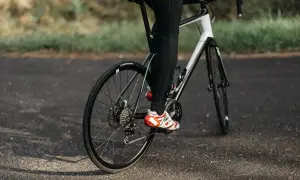 Rowerzysta w sportowych butach pedałuje, utrzymując optymalną kadencję rower.