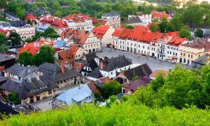 Urokliwe miasteczko z czerwonymi dachami, idealne na weekend w Lubelskiem. Zieleń otacza zabytkowe kamienice.