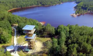 Wieża widokowa nad jeziorem w dawnej kopalni Babina. Woda ma nietypowy, fioletowy kolor.
