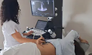 Lekarka wykonuje badanie **ultradźwiękami** u pacjentki. Na monitorze widoczny obraz USG.