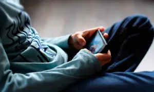 Ein digitaler Mensch, vertieft in sein Smartphone. Die Hände halten das Gerät, während der Blick auf den Bildschirm gerichtet ist.