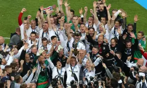 Piłkarze Legii świętują zdobycie kolejnego trofeum, podnosząc puchar. Ile mistrzostw Polski ma Legia? Tyle, ile radości na ich twarzach!
