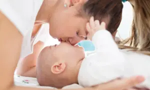 Czuły pocałunek mamy dla jej 5-miesięcznego dziecka.