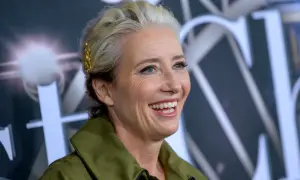 Uśmiechnięta Emma Thompson, znana z wielu wspaniałych filmów, z blond włosami ozdobionymi złotą spinką.