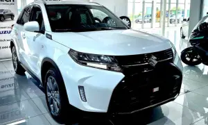 Biały Suzuki Vitara Hybrid błyszczy w salonie, gotowy na miejskie przygody.