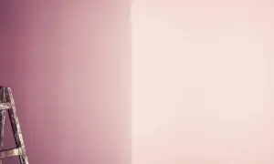 Alte Leiter steht vor einer Wand, die in zwei Rosatöne geteilt ist. Perfekt für das **Wandfarbe mischen** für ein neues Projekt.